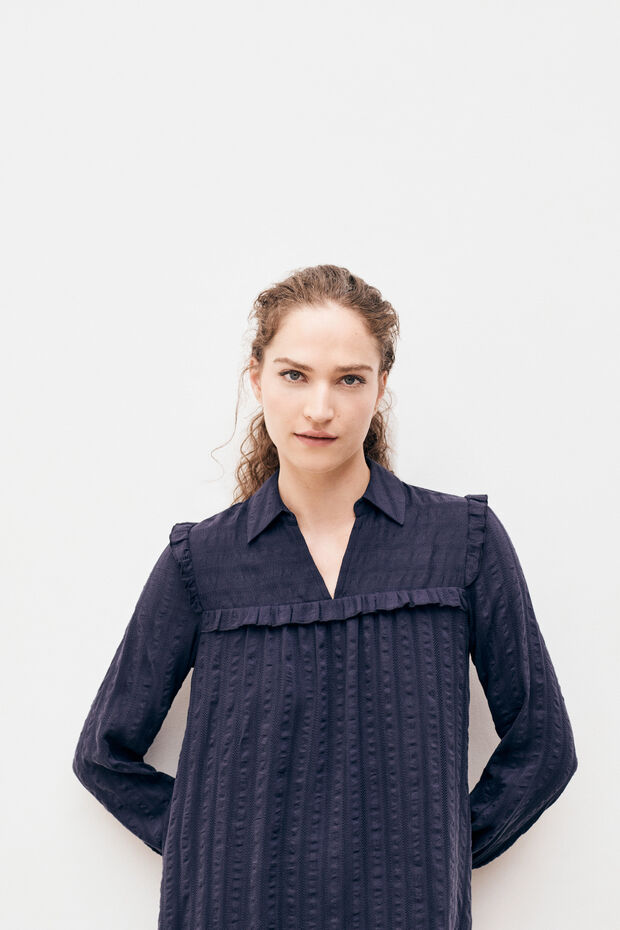 Robe en lyocell texturé. Coupe droite et fluide décorée de volants féminins.